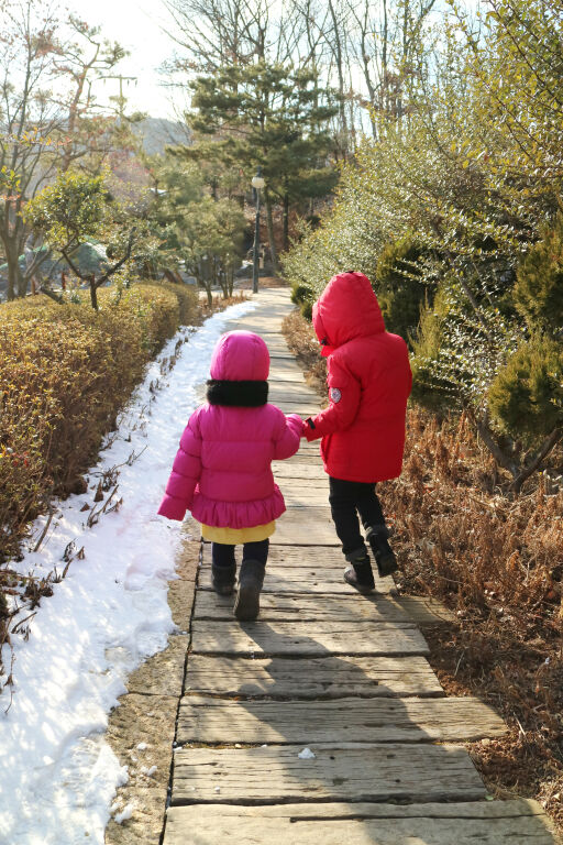 나무판 길을 걷고 있는 어린이 두명